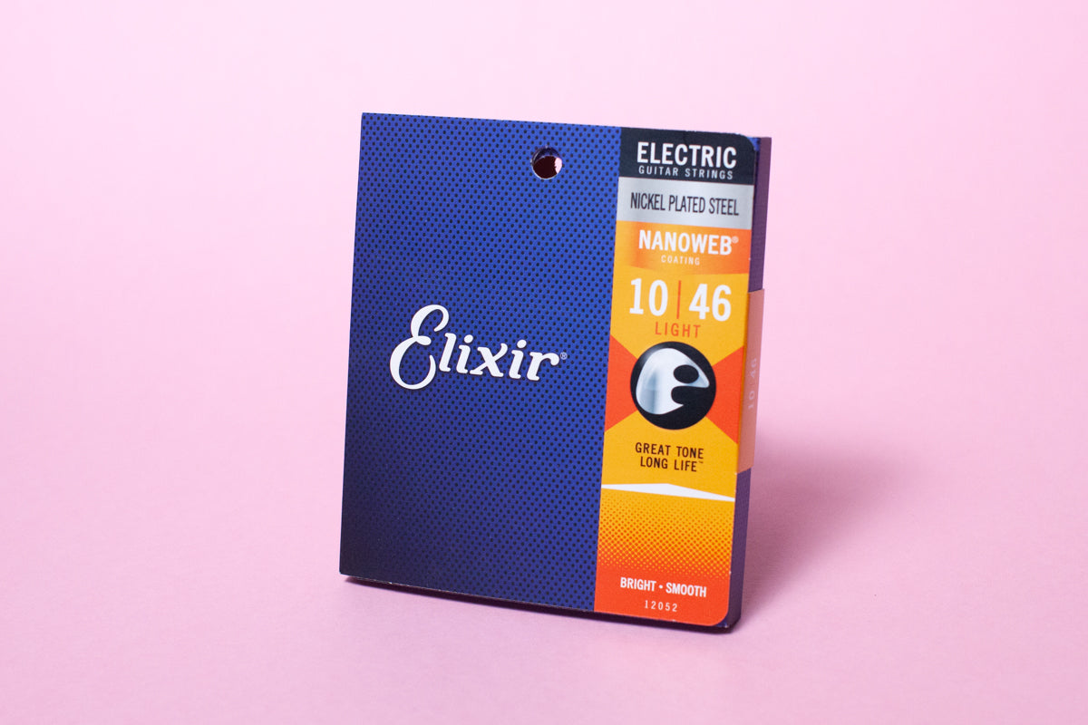 A pack of Elixir Nanoweb coated nickel plated steel electric guitar strings with gauges 10-46, displayed against a pink background.