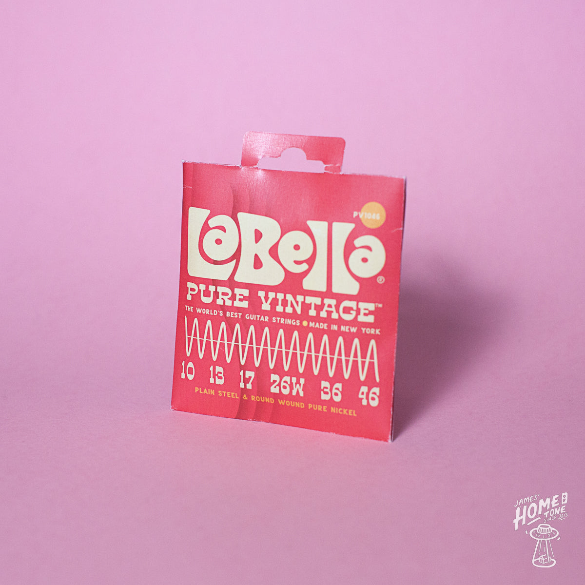 A package of La Bella Pure Vintage electric guitar strings in a pink background, featuring a list of string gauges from 10-46.