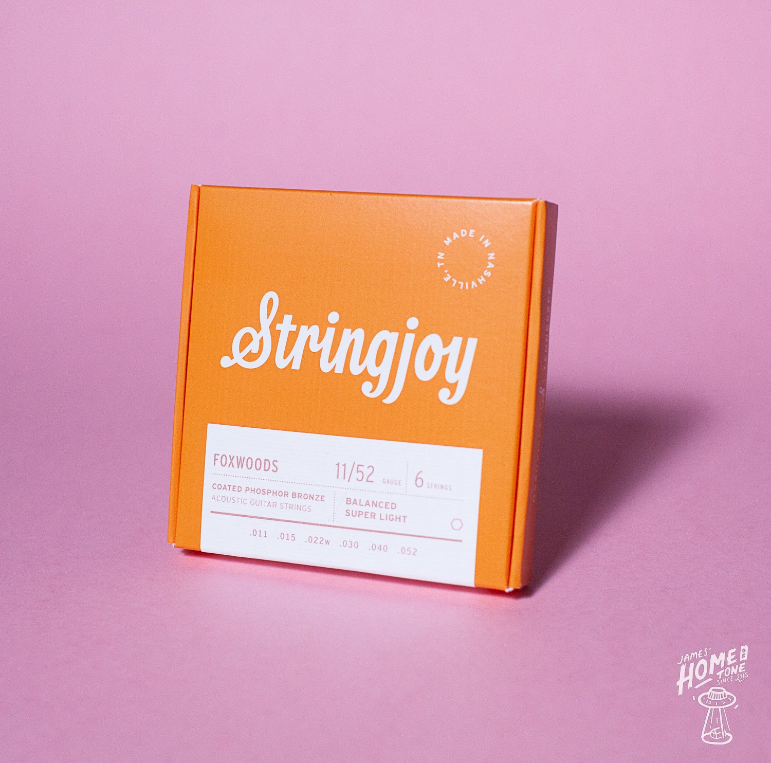 An orange box of Stringjoy Foxwoods coated phosphor bronze acoustic guitar strings with the text 'Super Light Gauge 11-52' displayed on it.