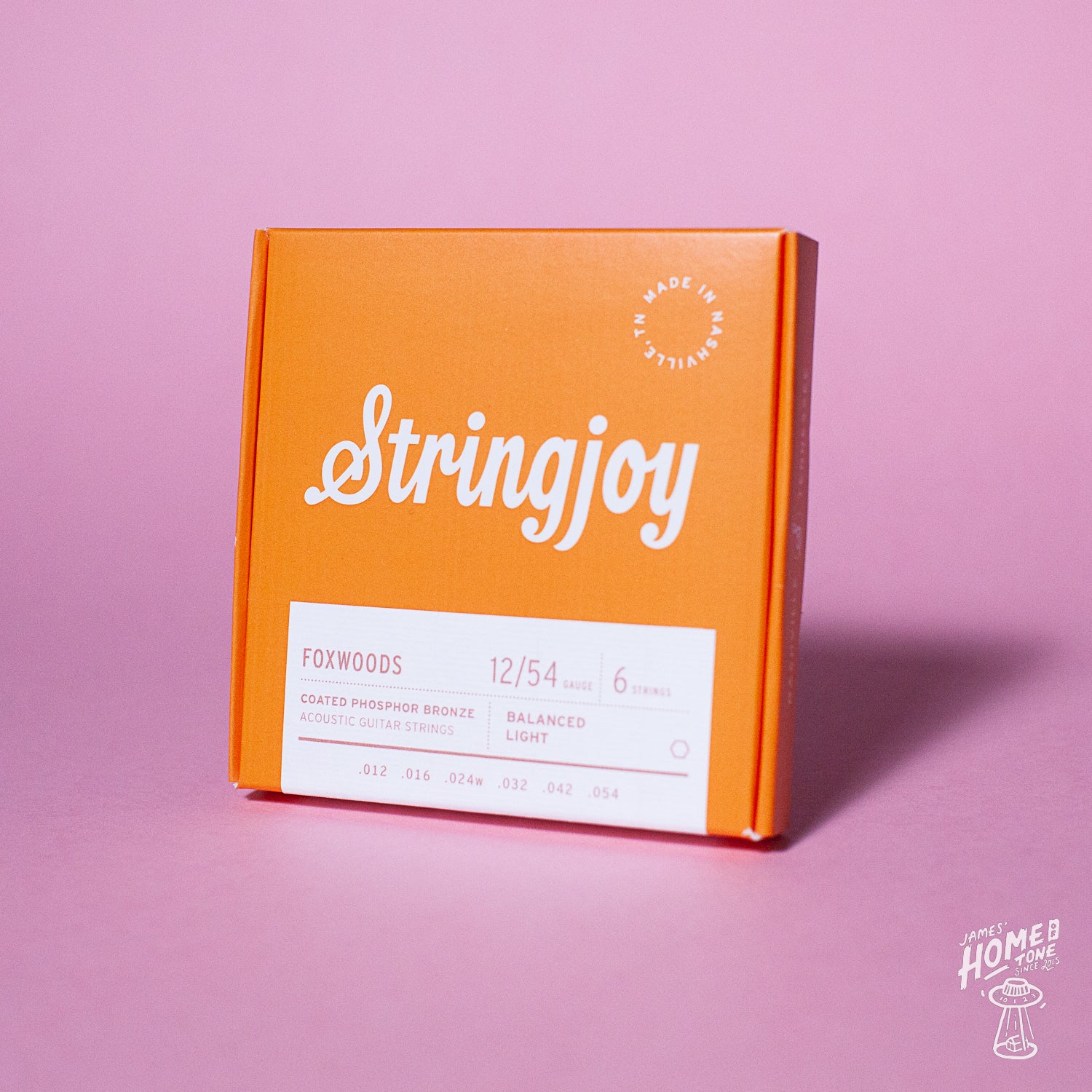 An orange box of Stringjoy Foxwoods coated phosphor bronze acoustic guitar strings with the text 'Stringjoy' and 'Foxwoods' on the front.