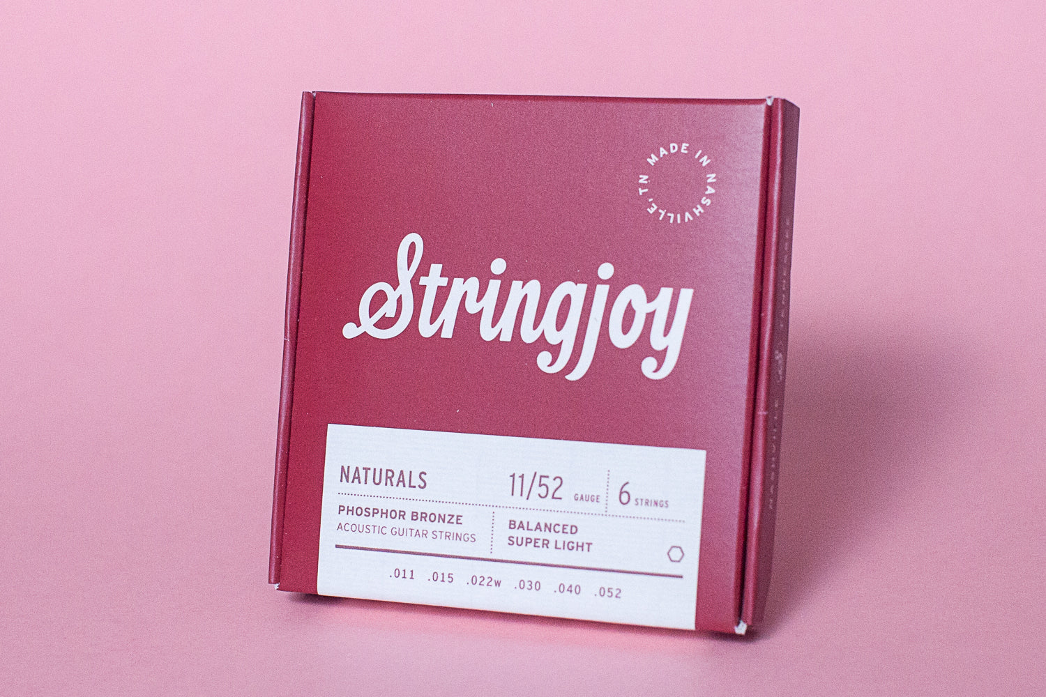Stringjoy guitar string box on a pink background