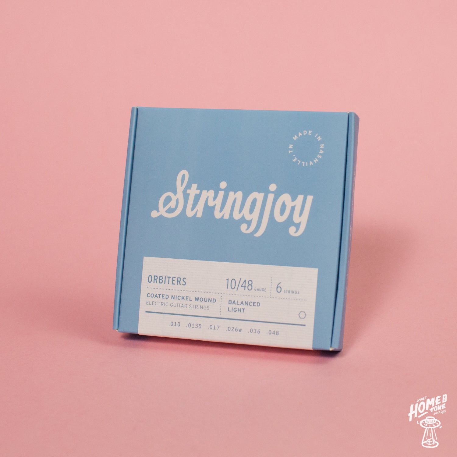 A pack of Stringjoy Orbiters coated nickel wound electric guitar strings with balanced light gauge, displayed against a pink background.
