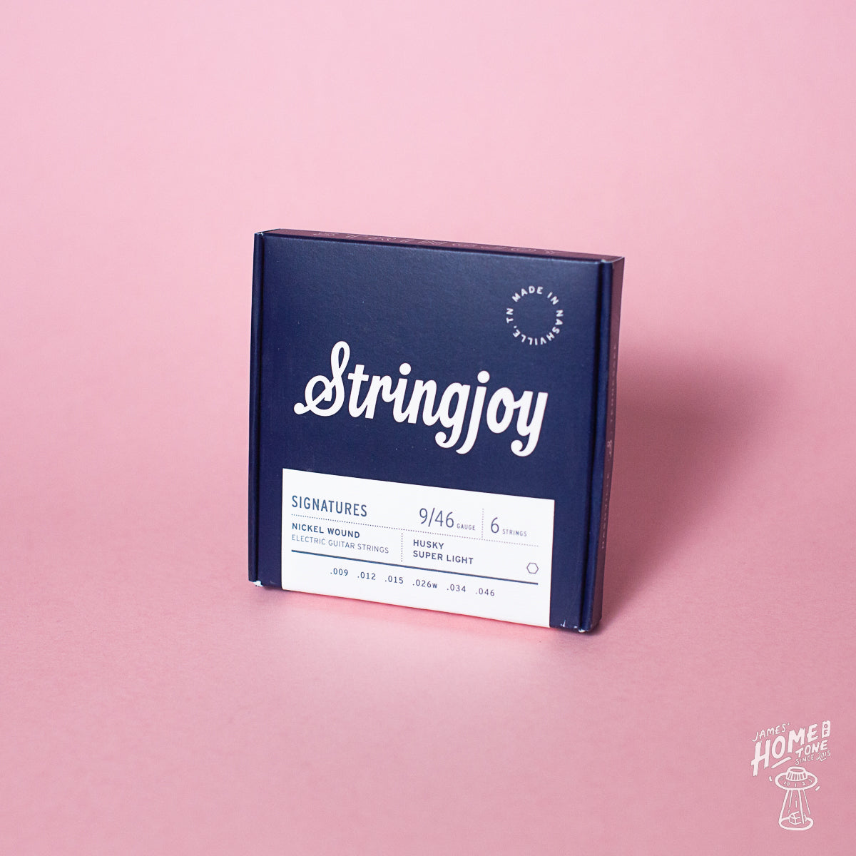 A box of Stringjoy Signature nickel wound electric guitar strings in Husky Super Light gauge, displayed against a pink background.