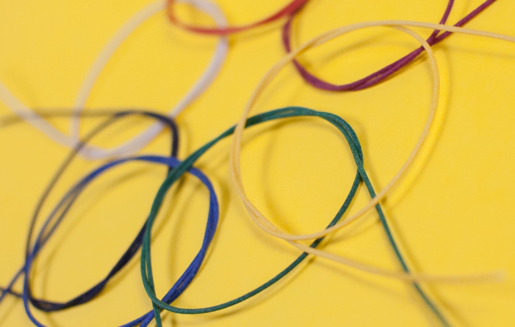 Assorted colors of Gavitt 22AWG cloth covered wires laid out on a yellow background.