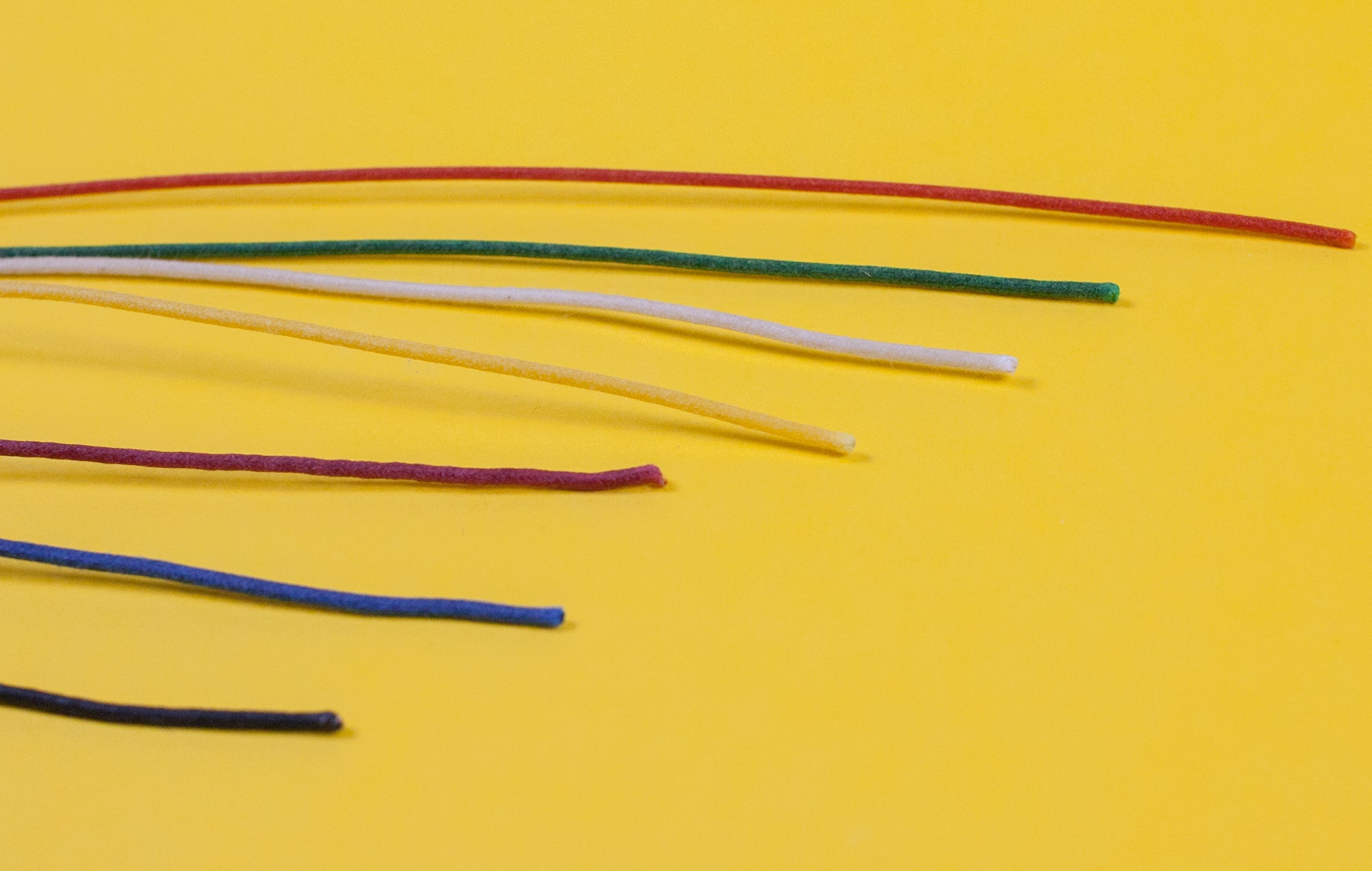 Assorted colors of Gavitt 22AWG cloth covered wires laid out on a yellow background.
