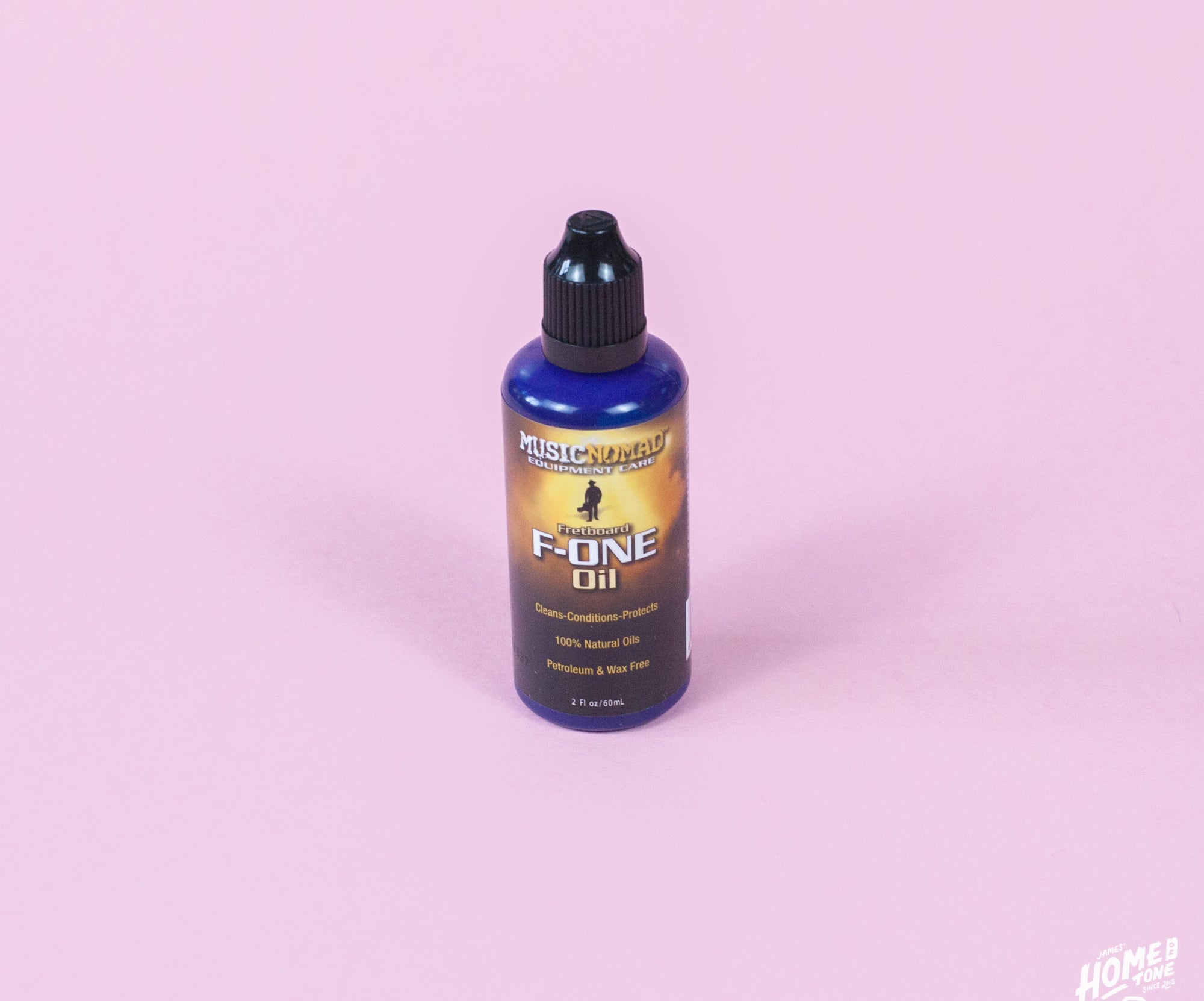 A bottle of MusicNomad Fretboard F-One Oil Cleaner & Conditioner on a pink background.
