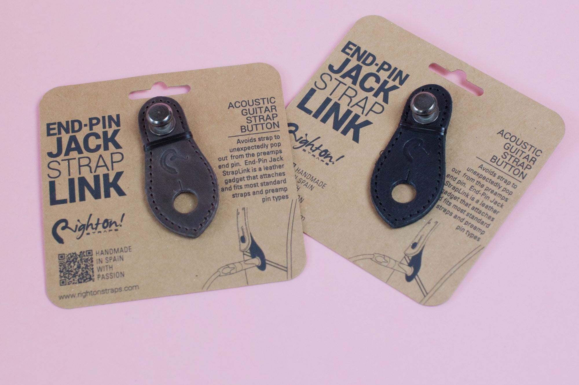 Two leather end-pin jack strap links on cardboard packaging, one brown and one black, with branding and product information.