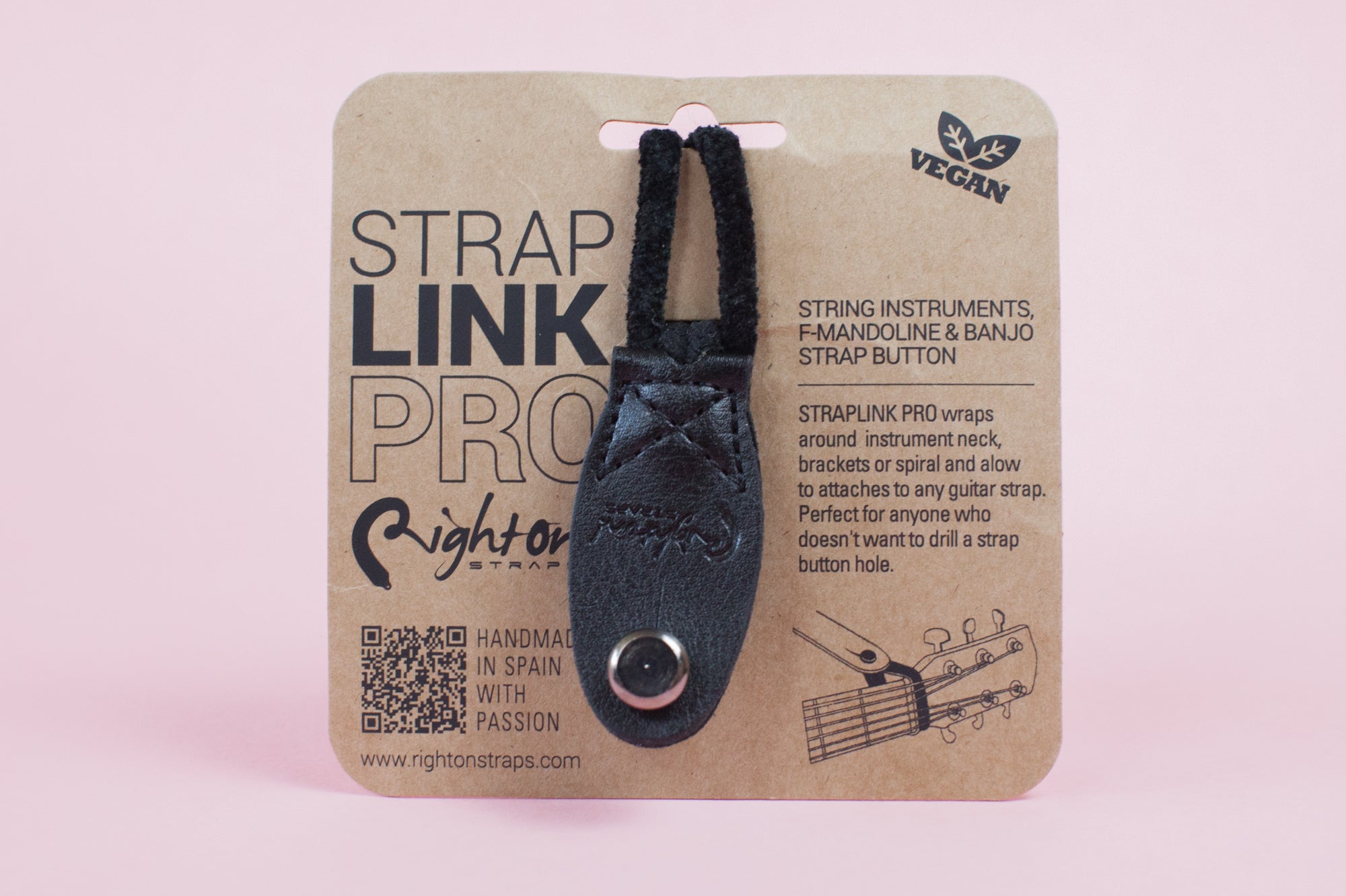 Neck Strap Link Pro accessories for guitars displayed on cardboard packaging, one brown and one black, on a pink background.