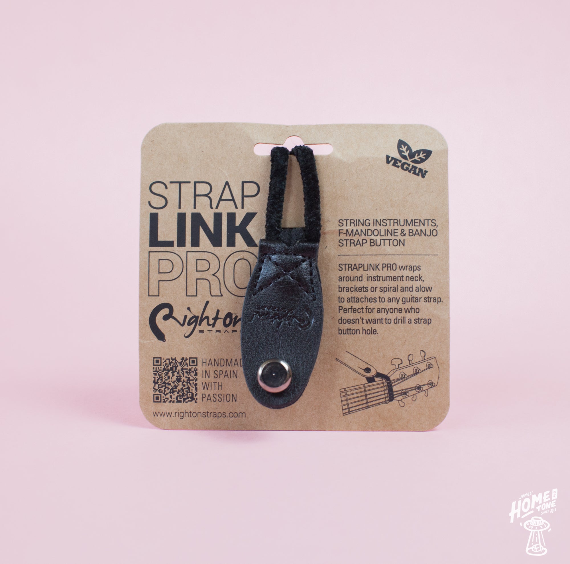 Neck Strap Link Pro accessories for guitars displayed on cardboard packaging, one brown and one black, on a pink background.
