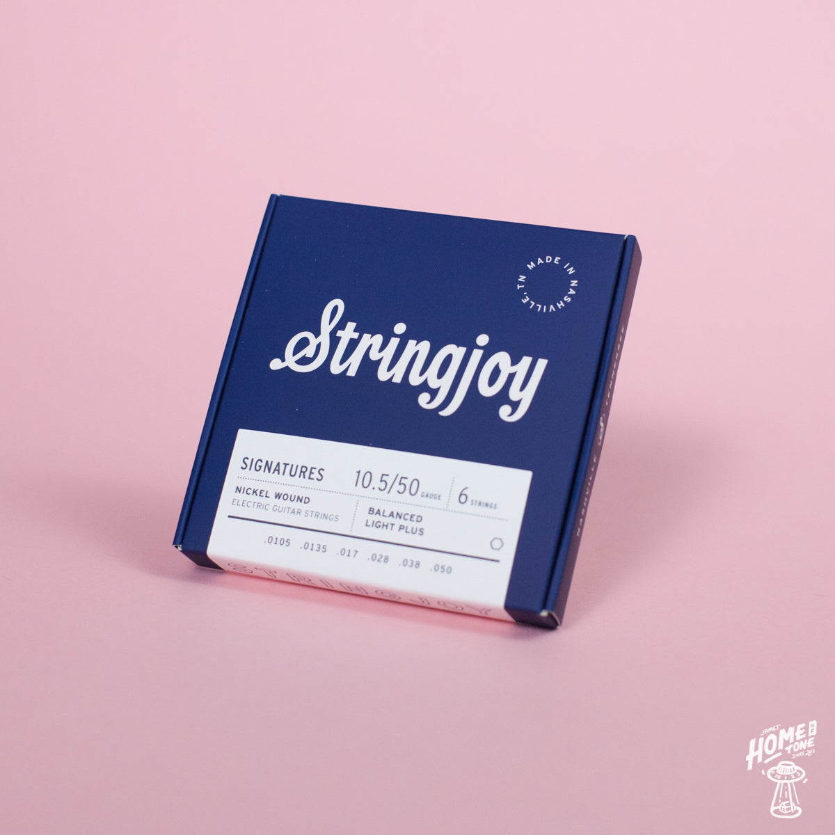 A box of Stringjoy Signature nickel wound electric guitar strings with balanced light plus gauges, displayed against a pink background.