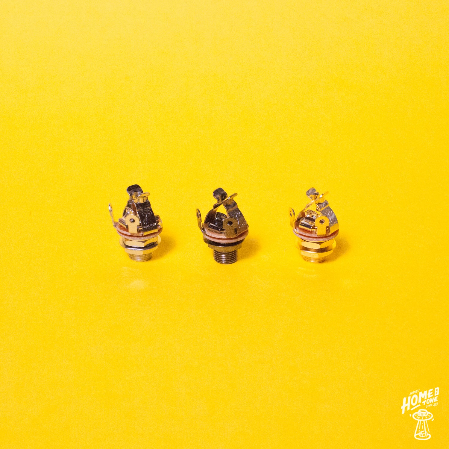 Three Pure Tone multi-contact 1/4" output jack sockets displayed on a yellow background, with the Home of Tone logo visible.