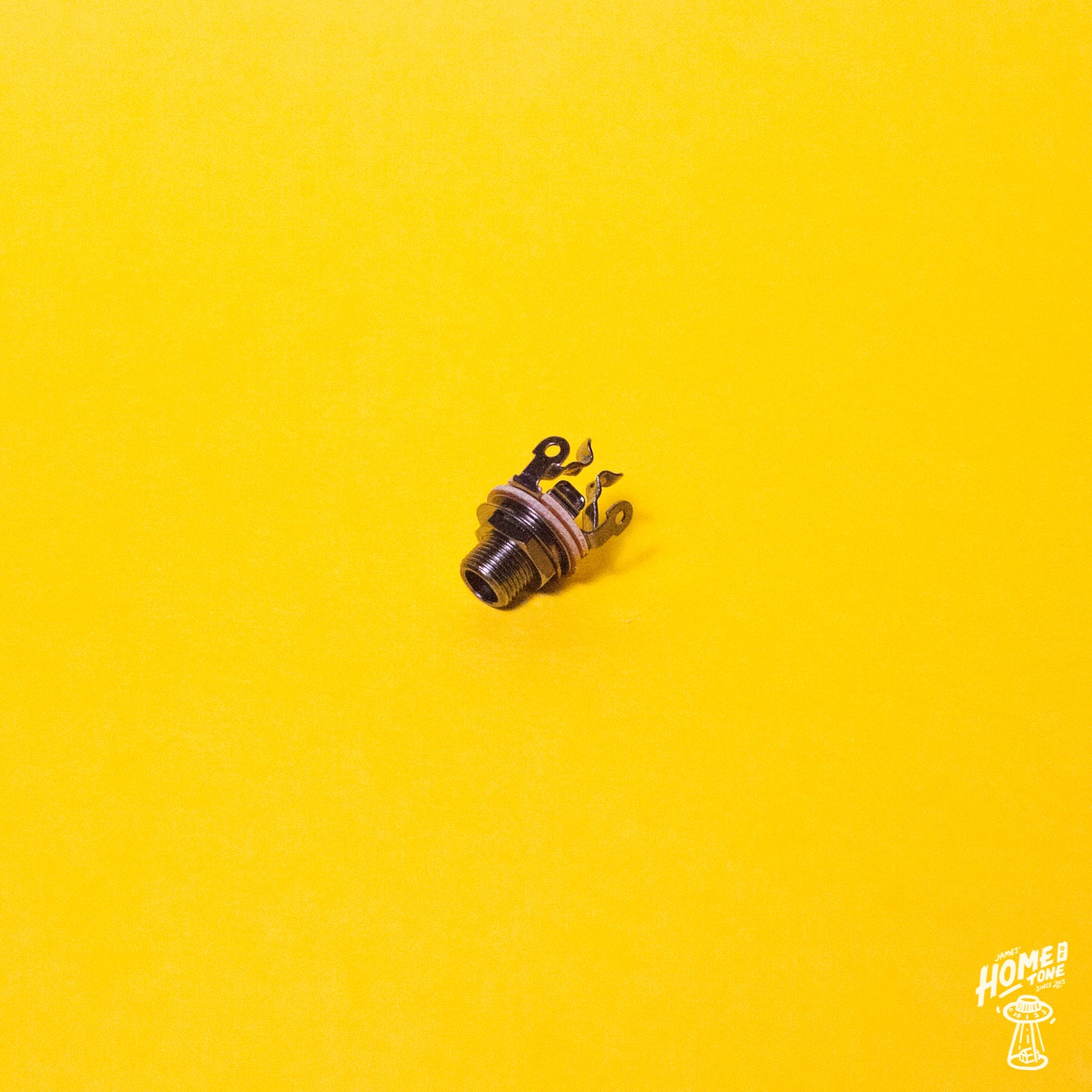 Black Nickel finish, pure tone multi contact mono jack socket for guitars and basses, displayed on a yellow background.