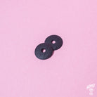 A pair of black rubber strap locks for guitars or basses, displayed on a pink background.