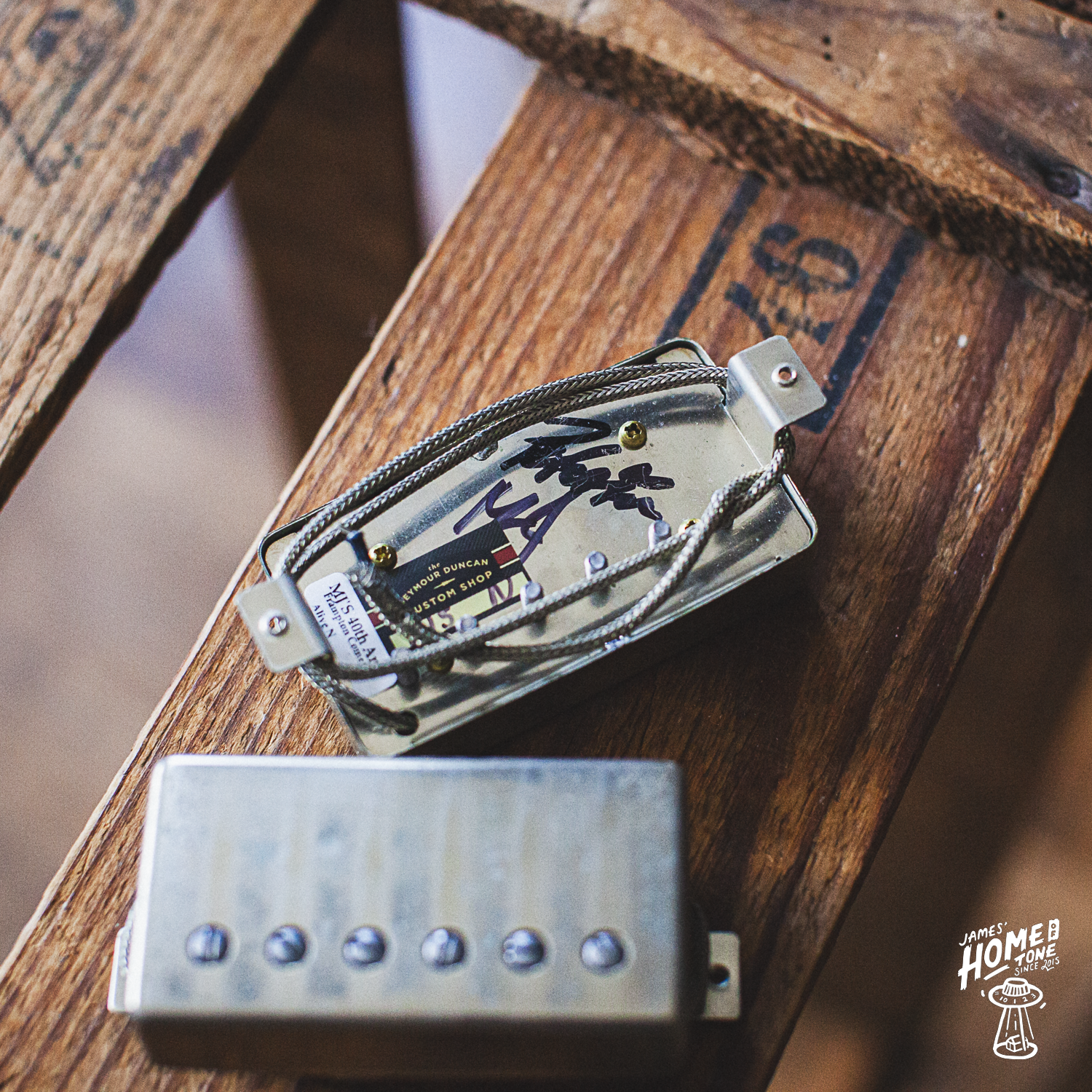 Guitar pickups signed by Peter Frampton on a wooden surface with a blurred background