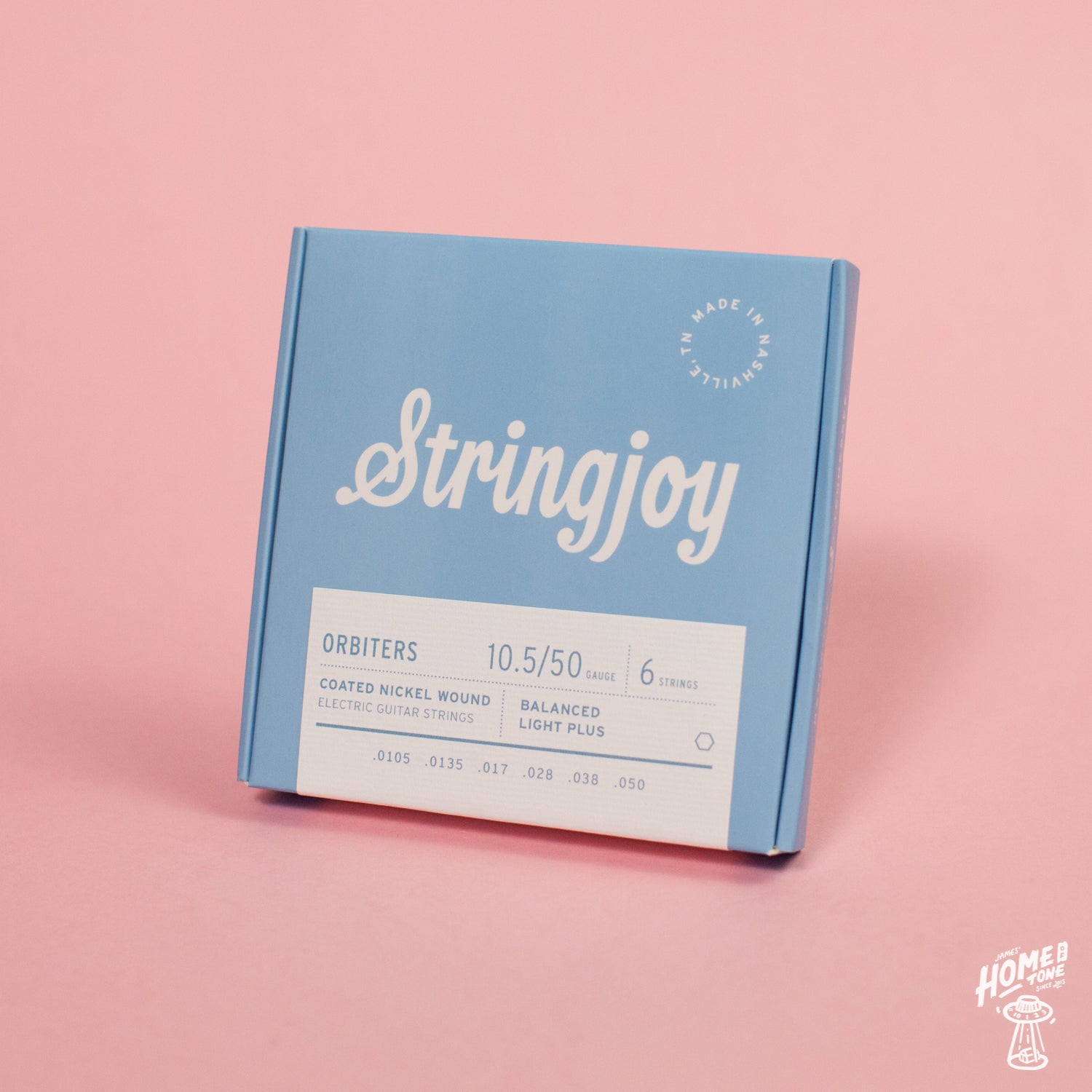 A box of Stringjoy Orbiters coated nickel wound electric guitar strings with balanced light plus gauge displayed on a pink background.
