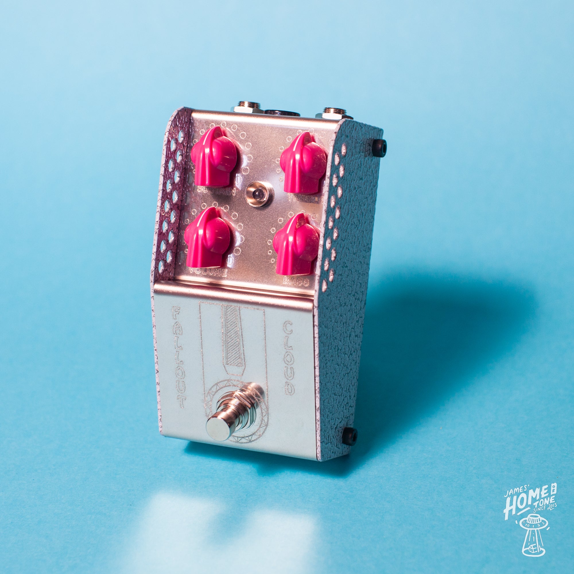 A silver-colored ThorpyFX pedal with a textured white enclosure and pink control knobs. It features red and black switches and a gold-plated PCB.