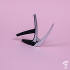 G7th - Nashville guitar capo with a silicone rubber and bar design, placed on a pink background.