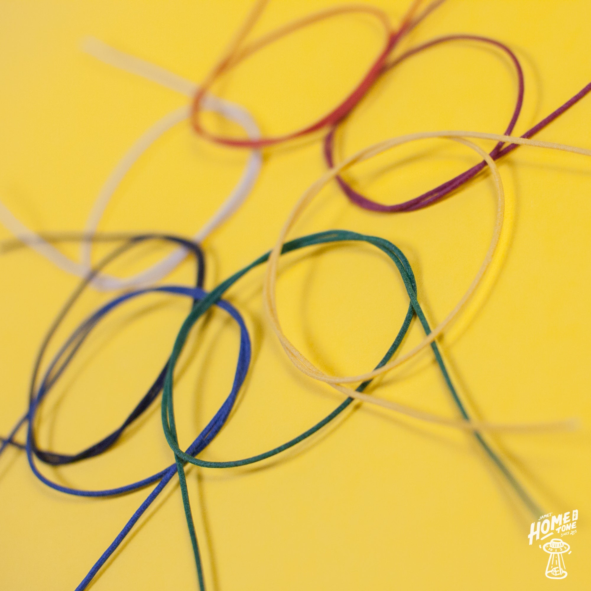 Assorted colors of Gavitt 22AWG cloth covered wires laid out on a yellow background.