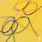 Assorted colors of Gavitt 22AWG cloth covered wires laid out on a yellow background.