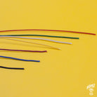 Assorted colors of Gavitt 22AWG cloth covered wires laid out on a yellow background.