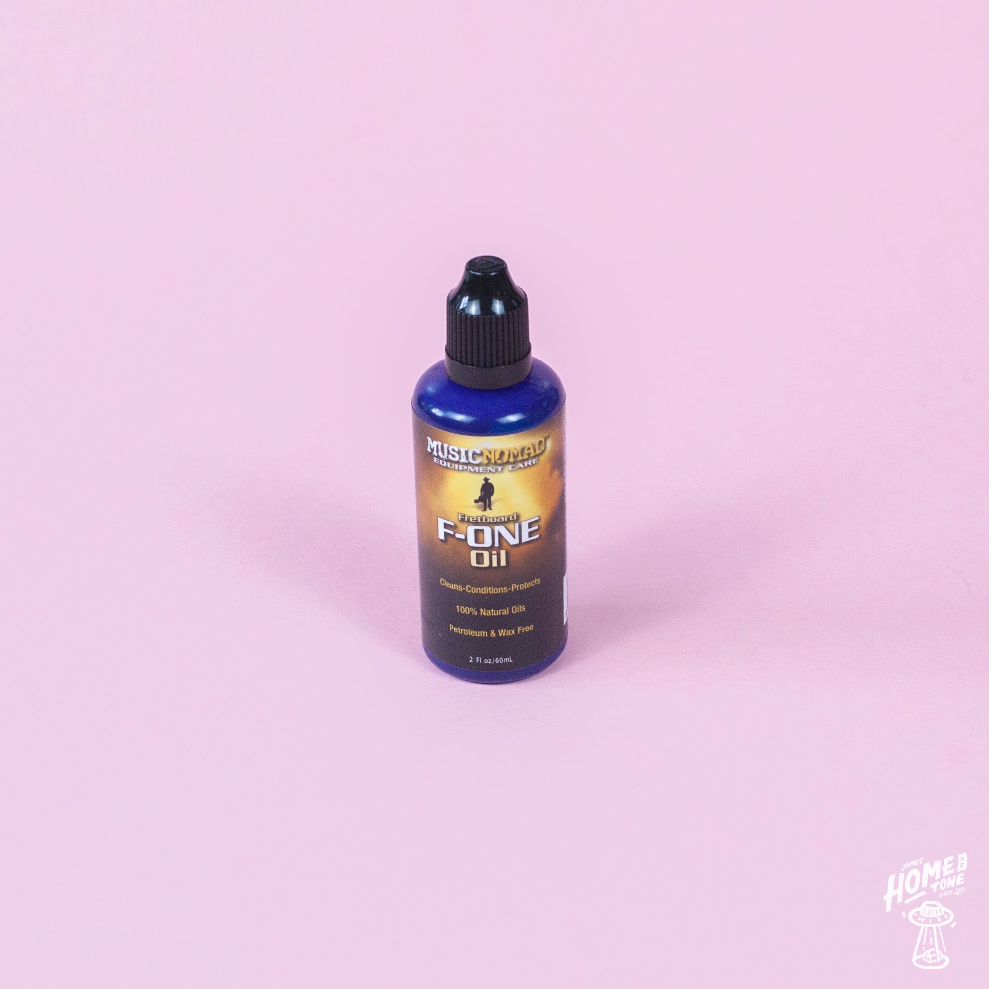 A bottle of MusicNomad Fretboard F-One Oil Cleaner & Conditioner on a pink background.