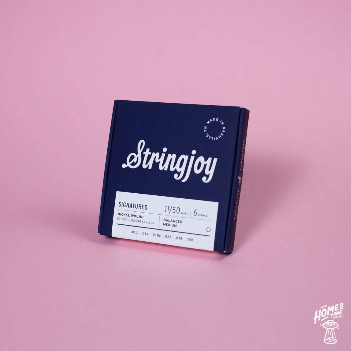 A box of Stringjoy Signature nickel wound electric guitar strings in medium gauge, displayed against a pink background.