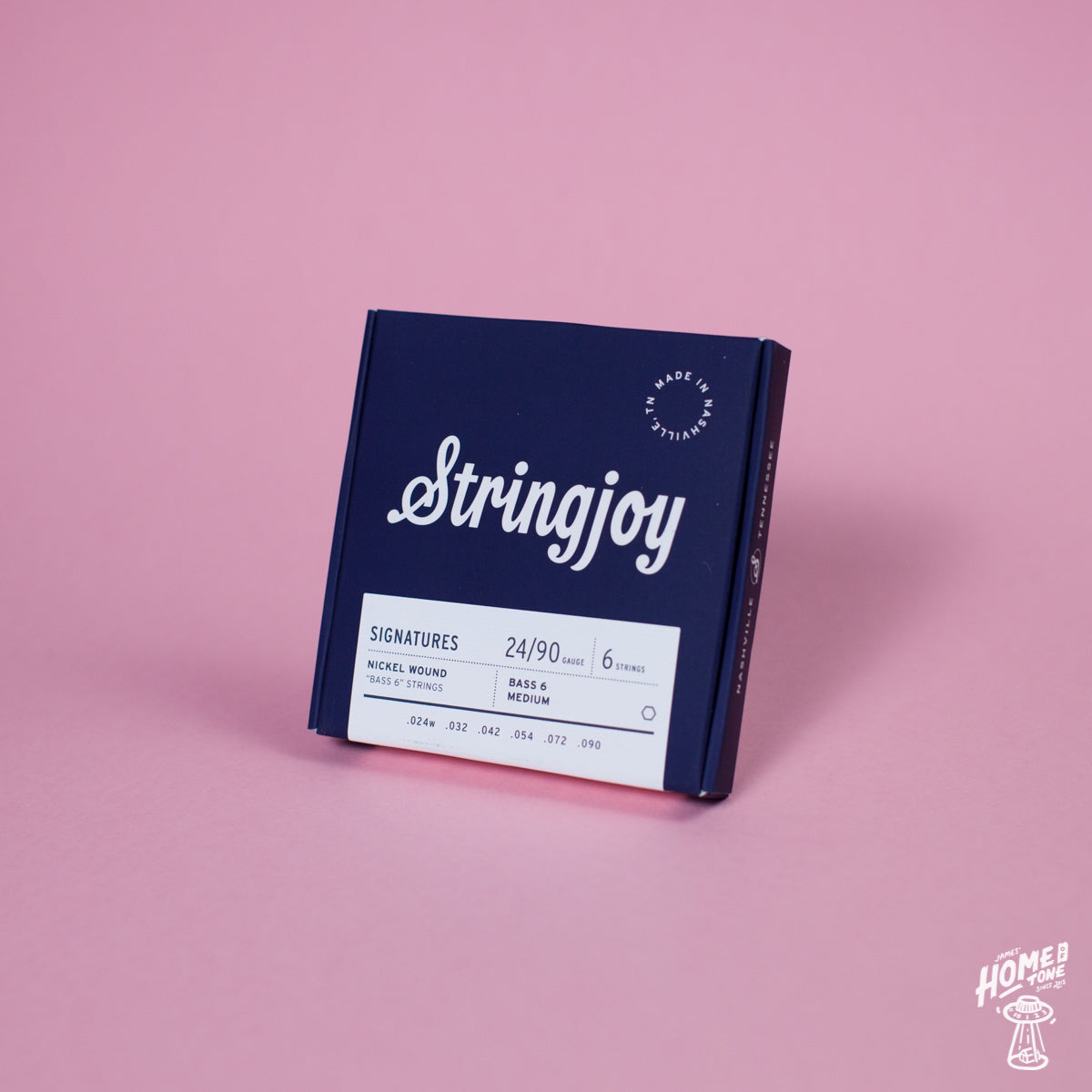 A pack of Stringjoy Signature nickel wound electric bass guitar strings, displaying the gauge size 24-90, placed on a pink background.