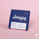 A box of Stringjoy Signature nickel wound electric guitar strings in Balanced Super Light Plus gauge, displayed against a pink background.